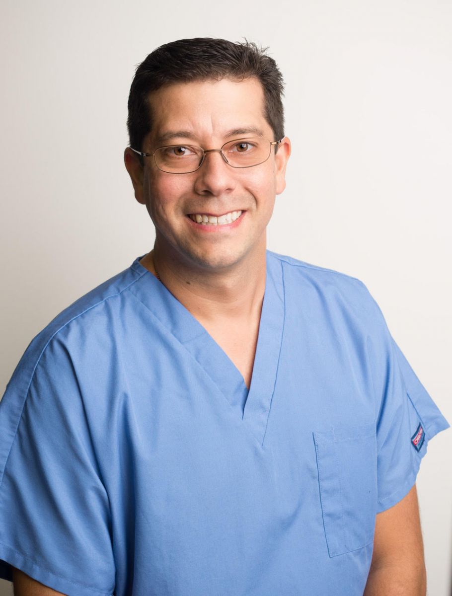 Dr. Andrés Guerra, board-certified oral and maxillofacial surgeon, in surgical scrubs