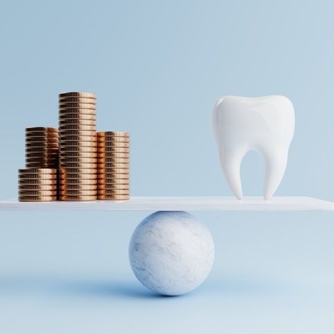 Coins and a tooth balanced on a scale
